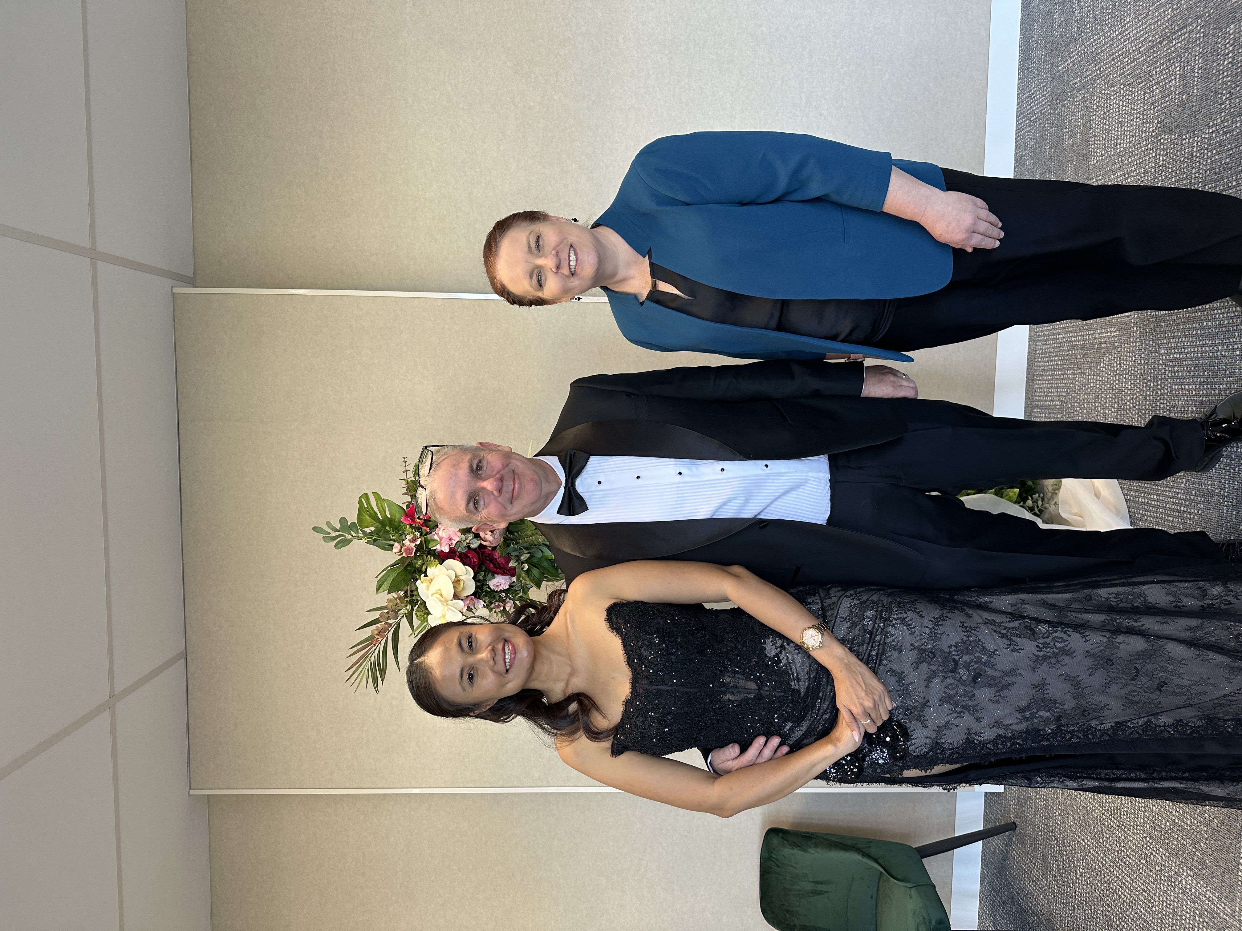 Allison Barker with a couple after an indoor wedding ceremony