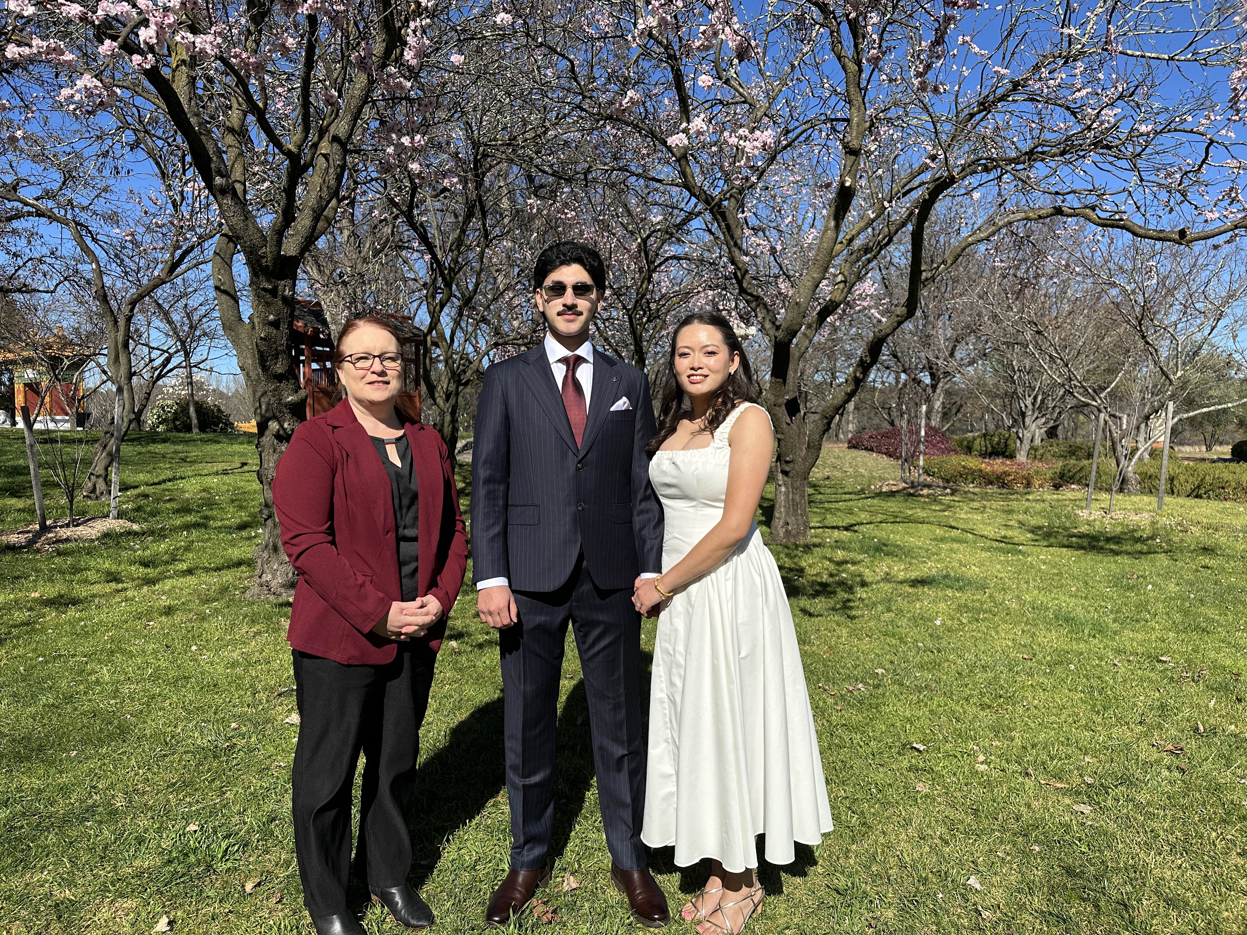 Allison Barker with a couple in a blossoming Canberra garden