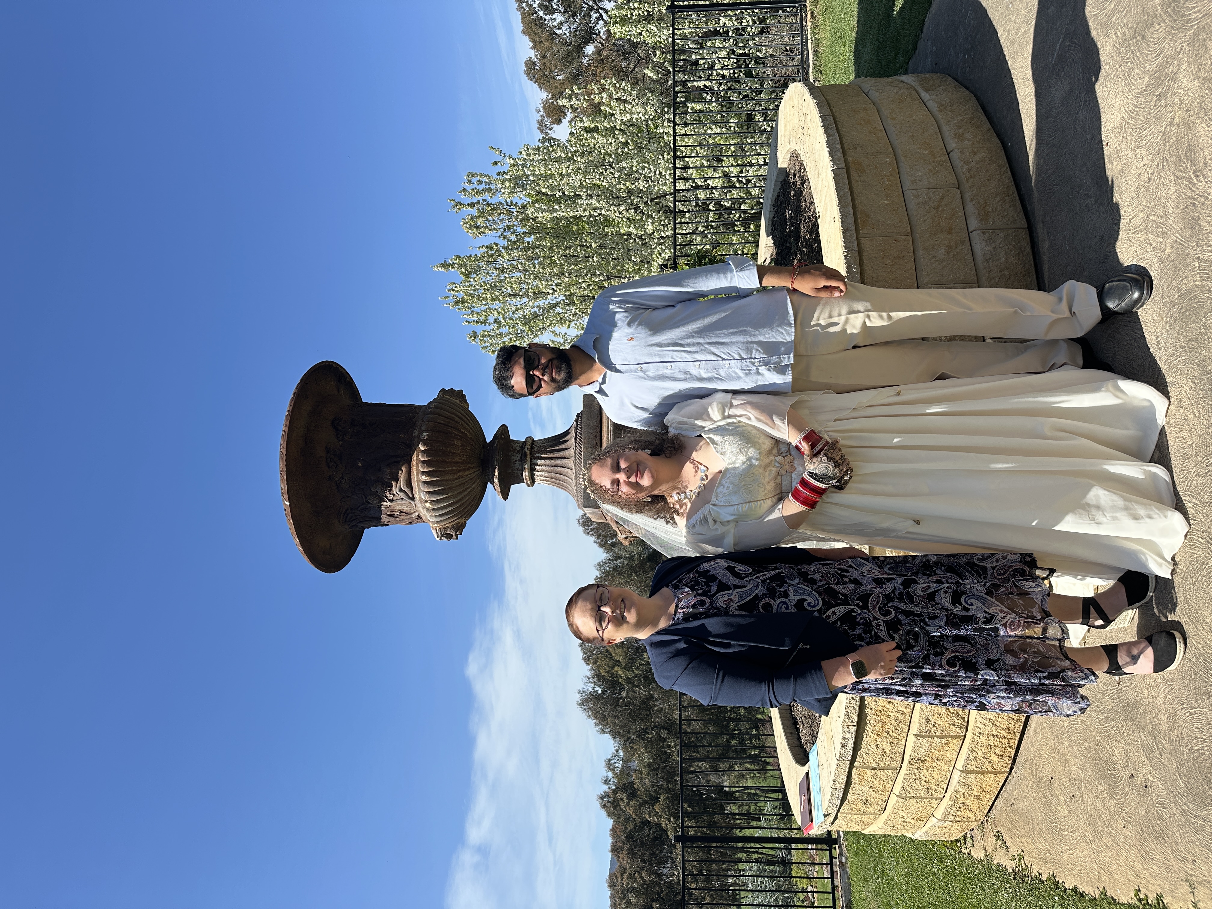 Allison Barker with a couple in a sunny outdoor garden setting